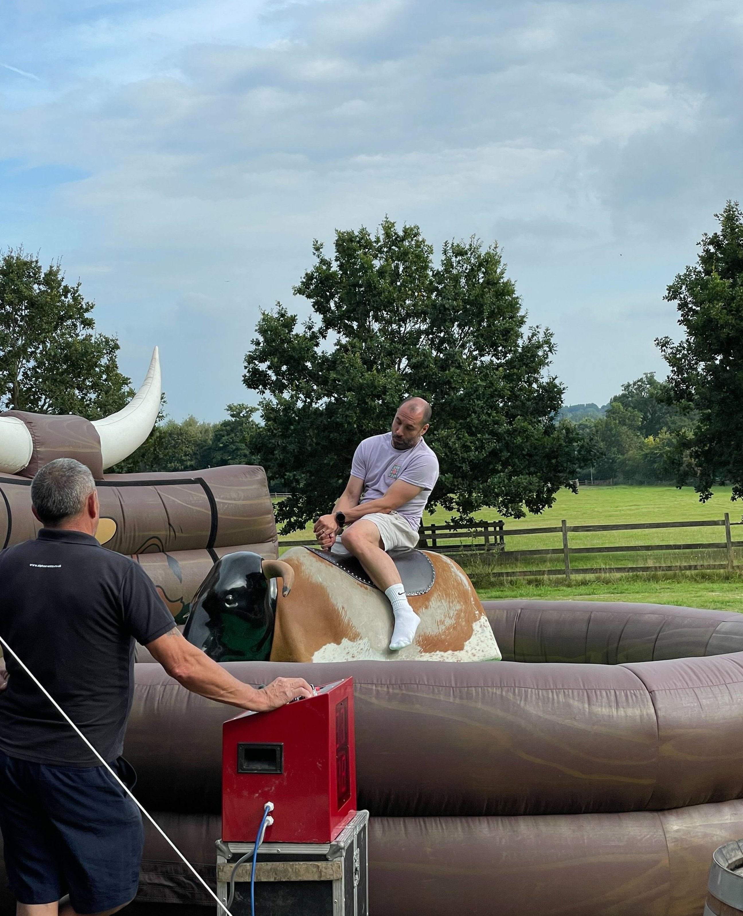 A group of hikers pose for a photo at a scenic hilltop viewpoint on a cloudy day, smiling and dressed in mixed hiking gear.