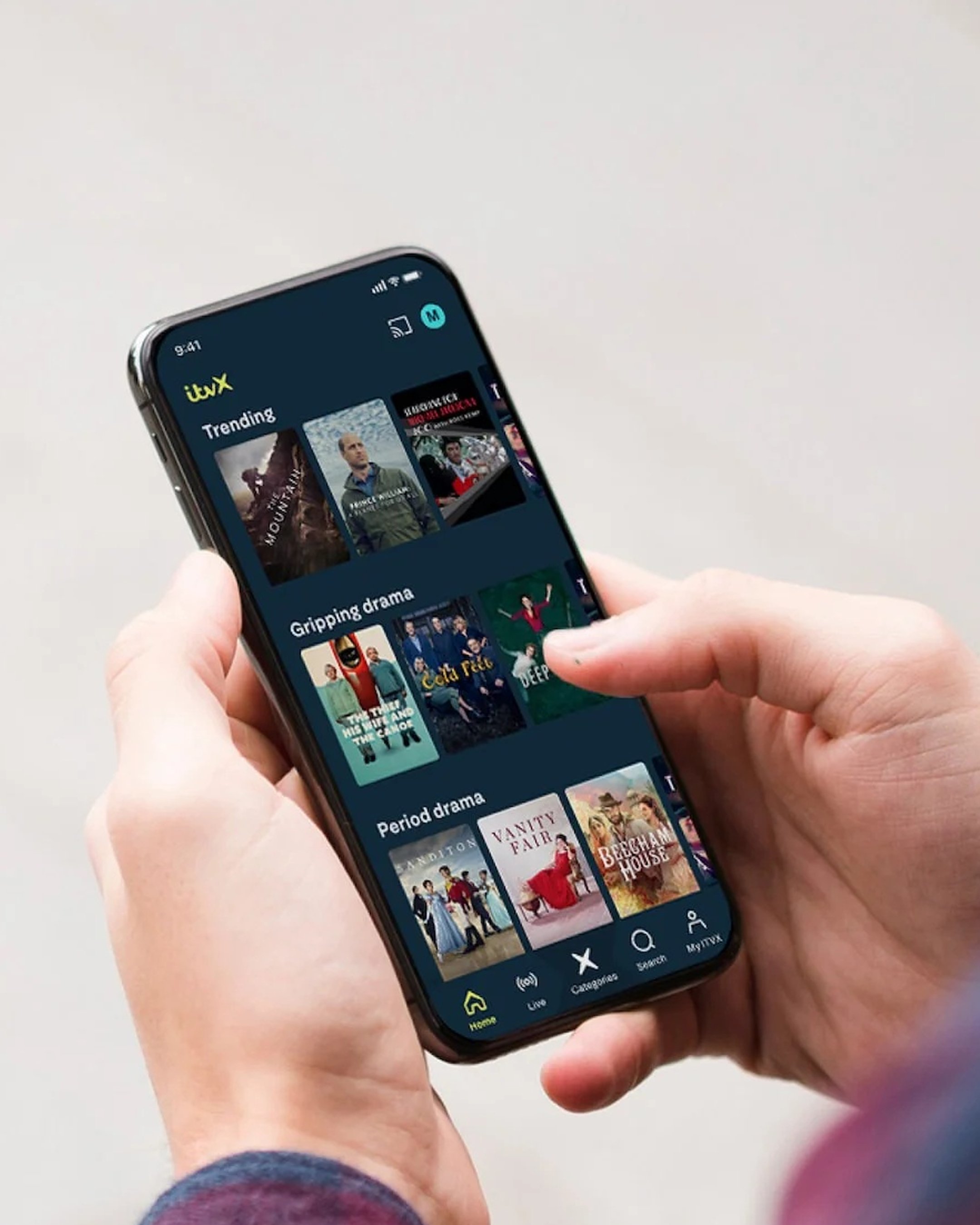 Phone in hand showing ITVX home screen (Trending / Gripping drama / Period drama rows)