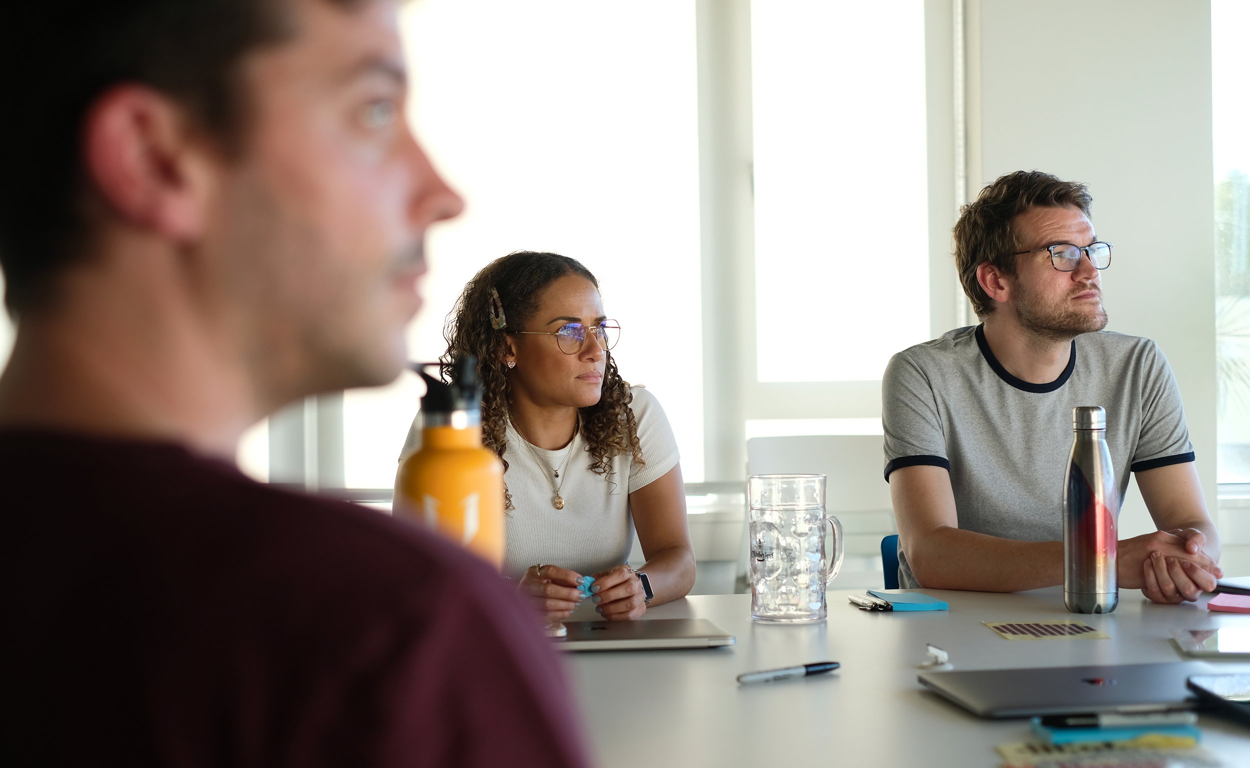 Team members collaborating around a desk in a modern office space
