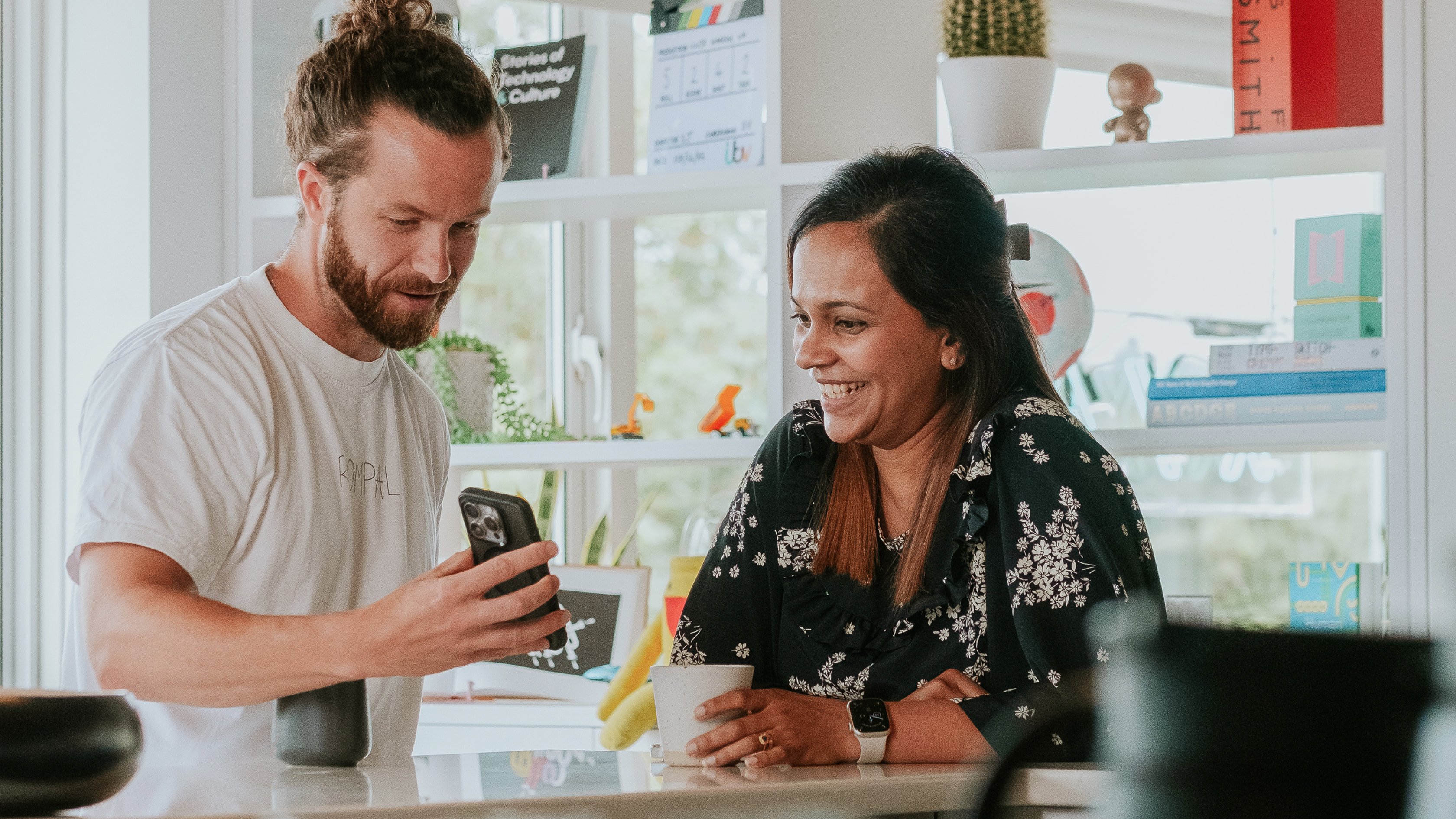 People looking at a phone together in an office