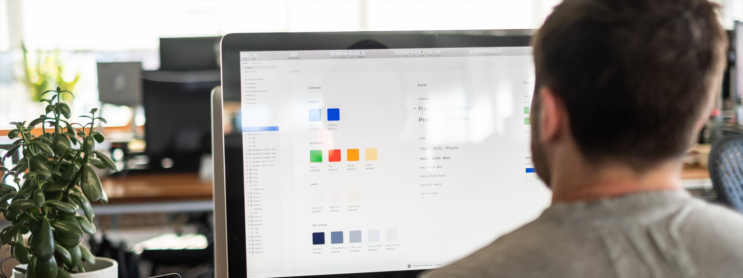 A developer inspects design system foundations on a large screen in an office