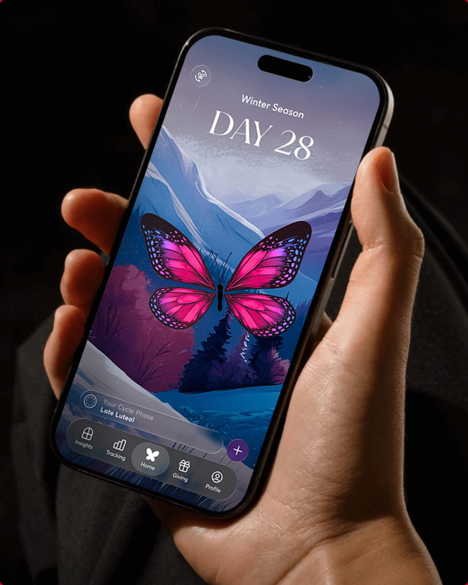 A hand holding an iPhone showing the 28X 'Winter Season, Day 28' home screen with a pink butterfly over a moonlit mountain landscape.