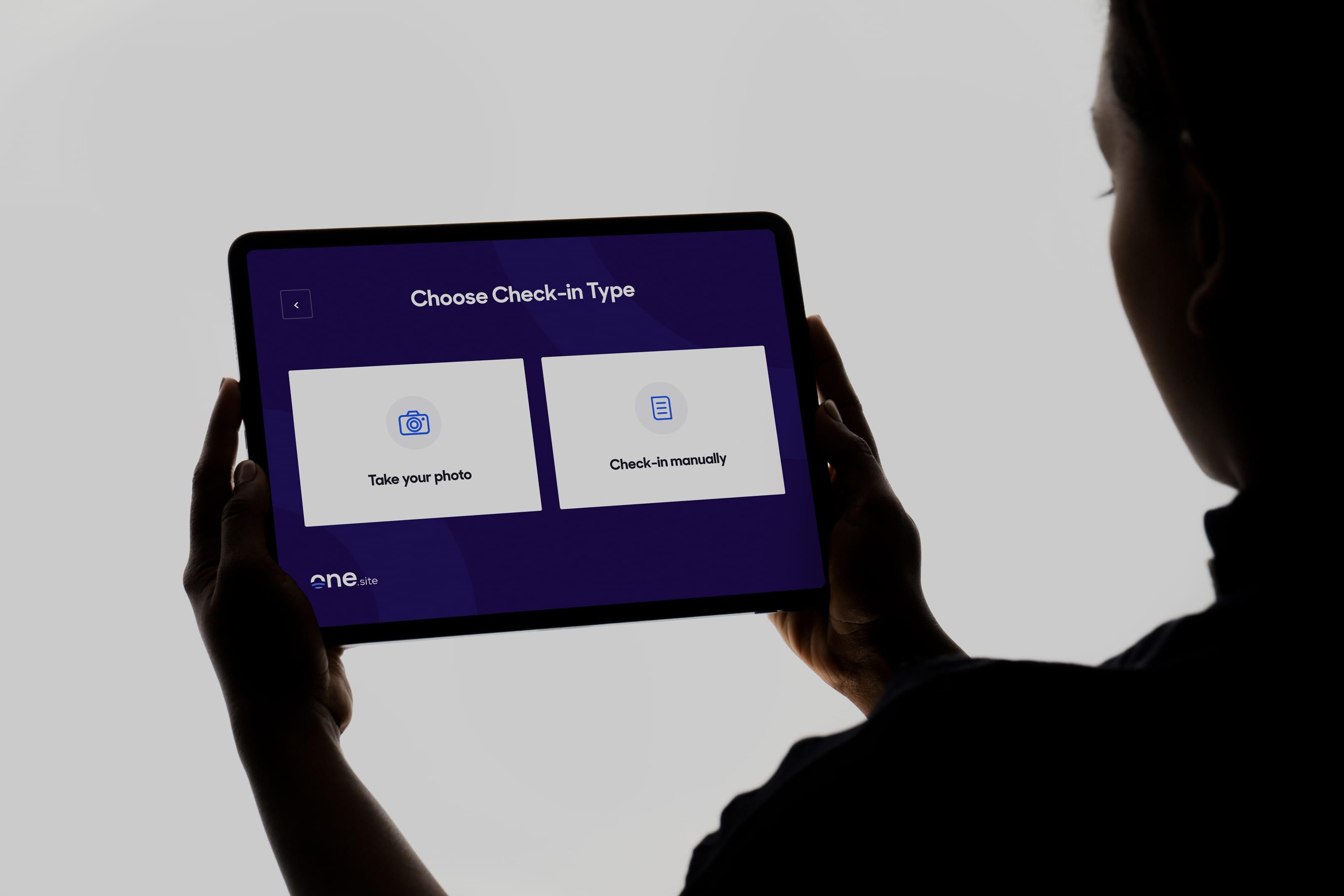 The One.site check-in screen showing a successful facial recognition match with a confidence score and site filter confirmation.