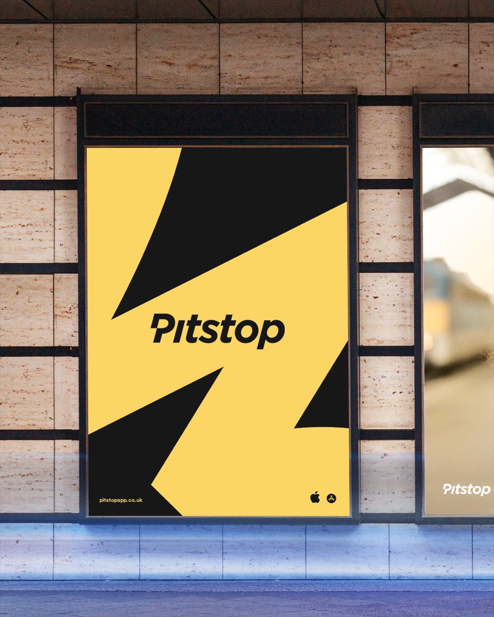 Poster in a transit station featuring the Pitstop logo over a bold yellow background with black angular graphic shapes.