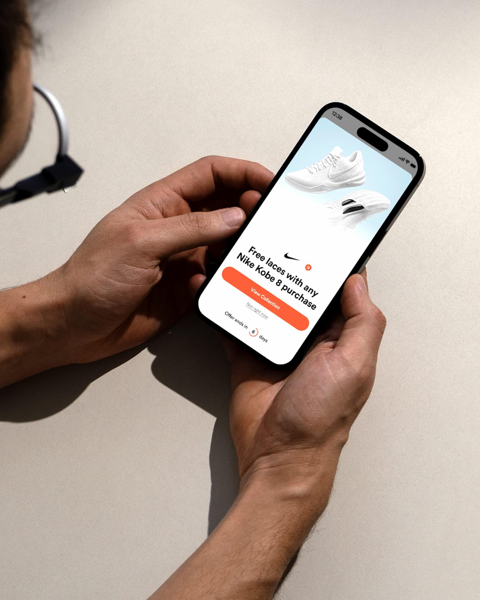 Person holding phone with Nike Kobe 8 promo