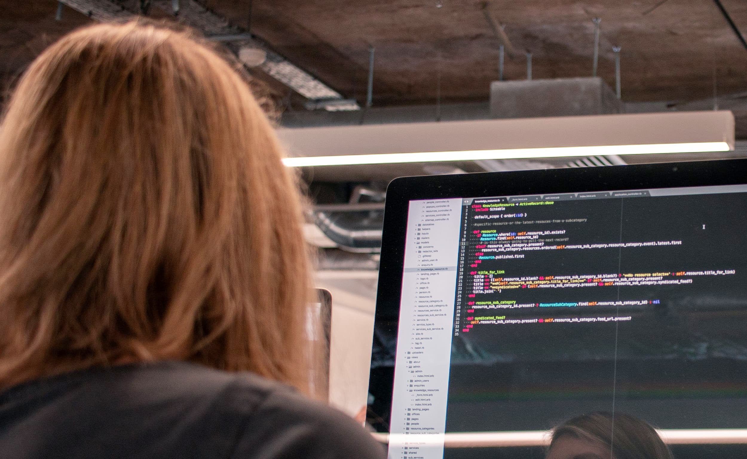 Person looking at code on a monitor (over-the-shoulder)