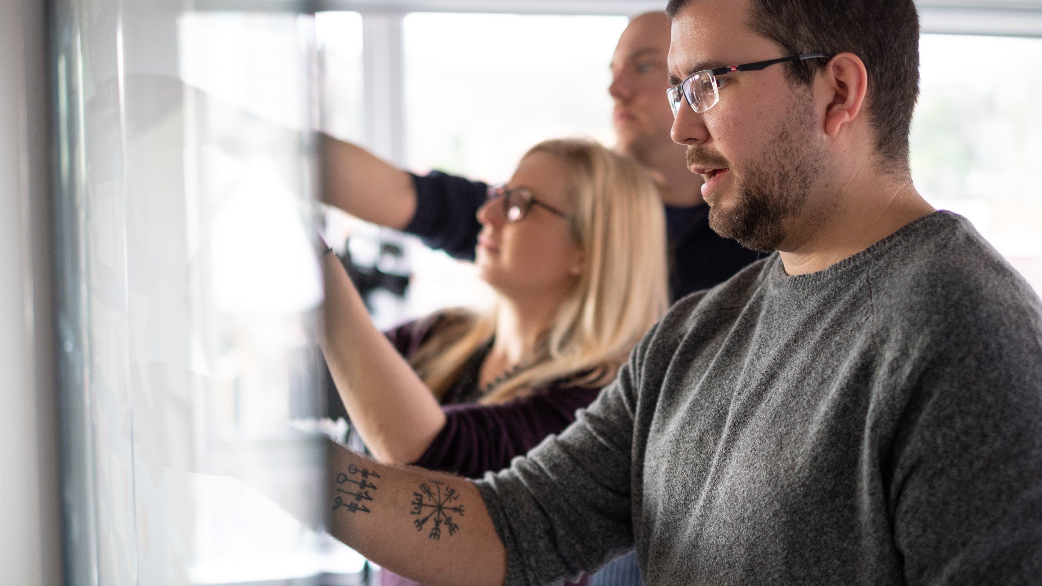 The team writing on a glass wall during a strategy workshop