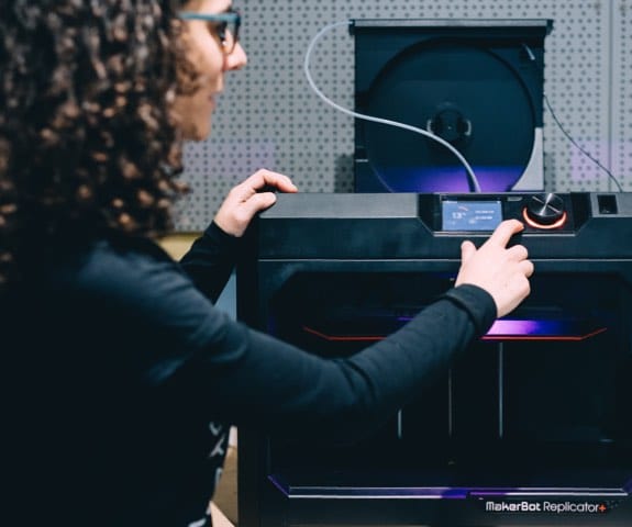 Carmen pointing at a 3D Printer